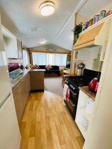 an open kitchen and living room in a tiny house at Older Style Caravan Pebble Bank T10 in Wyke Regis