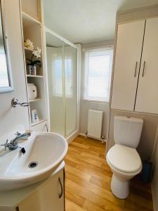 a bathroom with a white toilet and a sink at Older Style Caravan Pebble Bank T10 in Wyke Regis