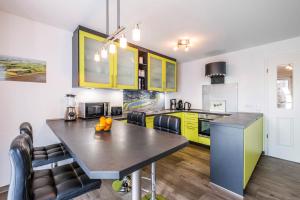 eine Küche mit gelben Schränken und einem Tisch mit Stühlen in der Unterkunft Haus Deichkieker Apartment 1 4 in Büsum + 7 Fotos