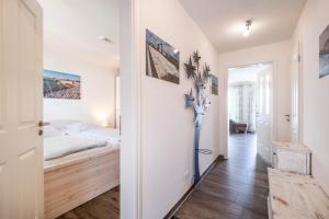ein Schlafzimmer mit einem Bett und einem Flur in der Unterkunft Haus Deichkieker Apartment 1 4 in Büsum