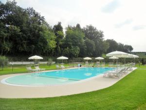 a large swimming pool with chairs and umbrellas at Appartamento Ai Prati in Lazise