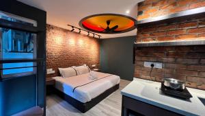 a room with a bed and a brick wall at Smile Hotel Seri Kembangan in Seri Kembangan