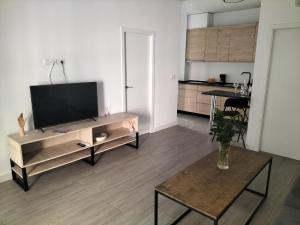 uma sala de estar com uma televisão de ecrã plano e uma mesa em Apartamento a estrenar Sevilla centro, Trastamara 19 em Sevilha
