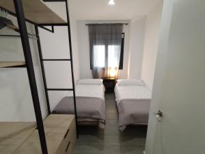 Zimmer mit 3 Etagenbetten und einem Fenster in der Unterkunft Apartamento a estrenar Sevilla centro, Trastamara 19 in Sevilla