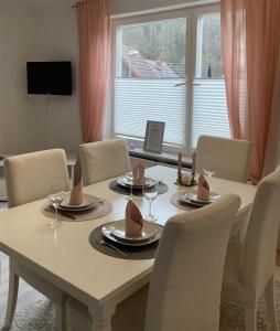 Una mesa de comedor con sillas y una gran ventana. en Ferienhaus Rübeland, en Neuwerk