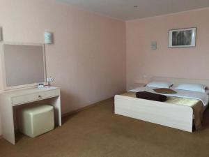 a bedroom with a bed with a television and a desk at Жеруйык Отель in Aktau