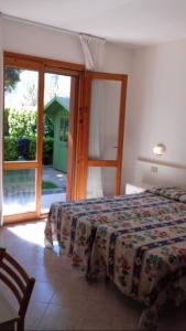 a bedroom with a bed and a large window at Appartanenti Arcadia in Caorle