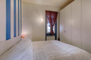 um quarto com uma cama branca e uma janela em Il nido sul mare - Affitti Brevi Italia em Torre del Lago Puccini