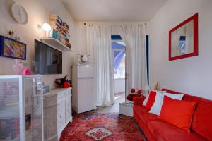 uma sala de estar com um sofá vermelho e uma televisão em Il nido sul mare - Affitti Brevi Italia em Torre del Lago Puccini