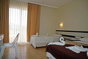 een hotelkamer met twee bedden met zwanen erop bij Aybel İnn Hotel in Beldibi