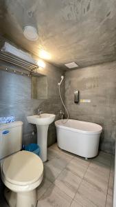 een badkamer met een toilet, een wastafel en een bad bij 漫旅溫泉會館-愛娜 in Jiaoxi