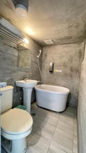 礁溪鄉的住宿－漫旅溫泉會館-愛娜，浴室配有卫生间、浴缸和水槽。