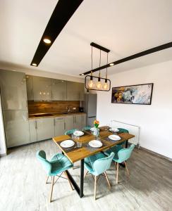 a dining room with a wooden table and blue chairs at NOVA House Apartments in Delniţa