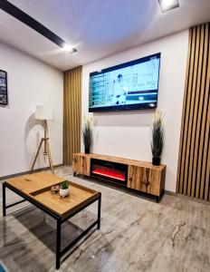 a living room with a flat screen tv on a wall at NOVA House Apartments in Delniţa