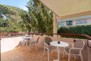 een patio met 2 tafels en stoelen op een balkon bij Deluxe Suites in Piano di Sorrento