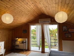 um quarto com paredes de madeira e tecto com duas luzes em House+garden near the sea em Áyioi Apóstoloi
