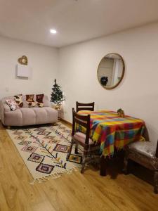 una sala de estar con un sofá y una mesa en Hermoso mini apartamento en el corazón de Bogotá, en Bogotá