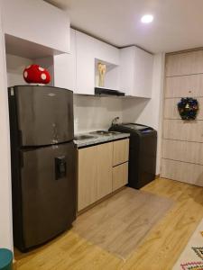 Una cocina con refrigerador de acero inoxidable y estufa. en Hermoso mini apartamento en el corazón de Bogotá, en Bogotá