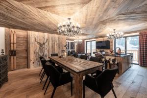 una sala da pranzo con tavolo e sedie in legno di Belvedere Elite a Canazei