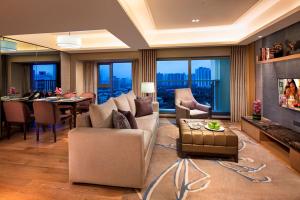 a living room with a couch and a dining room at Somerset Grandview Shenzhen in Shenzhen
