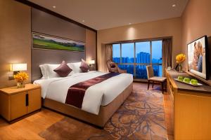 a bedroom with a large bed and a large window at Somerset Grandview Shenzhen in Shenzhen