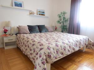 Un dormitorio con una cama con una colcha floral. en Apartments Grubisin, en Tribunj
