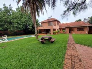 un tavolo da picnic nel cortile di una casa di Contemporary spacious guesthouse surrounded with green garden and pool in Mount Pleasant - 2063 a Kingsmead