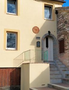 una casa con una escalera que conduce a la puerta principal en La casa di Mastro Ivetto en Arcevia