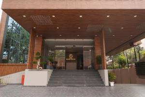 eine Lobby eines Gebäudes mit einer Treppe davor in der Unterkunft Hotel Grand Alleppey in Alappuzha
