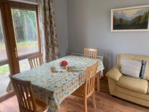 einen Esstisch und Stühle mit einem Tisch und einem Sofa in der Unterkunft No 14 Holiday Village House, Sneem, 4 bedrooms in Sneem