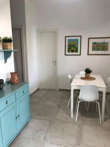 a kitchen with a table and a white table and chairs at BREZZA DI LEVANTE in Cefalù