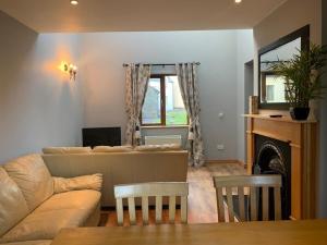 a living room with a couch and a fireplace at No 14 Holiday Village House, Sneem, 4 bedrooms in Sneem