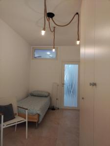 een slaapkamer met een bed, een stoel en een deur bij TWIN HOUSE brown in Tito