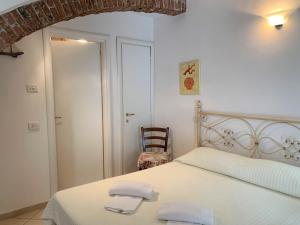 a bedroom with a white bed with two towels on it at Appartamenti Sentiero n1 in Levanto