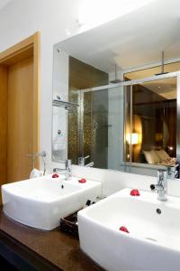 a bathroom with two white sinks and a mirror at Hotel Terminus Maputo in Maputo