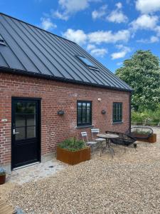 a red brick building with a black door and a patio at GaestFri Overnatning in Gjern