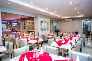 een eetkamer met rode tafels en witte stoelen bij Hotel Terminus Maputo in Maputo