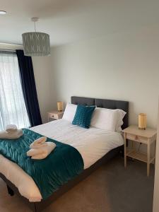 a bedroom with a large bed with two towels on it at Number 15 Luxurious Two Bedroom Apartment in Exmouth