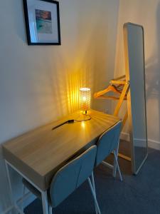 una mesa de madera con 2 sillas y una lámpara. en Number 15 Luxurious Two Bedroom Apartment en Exmouth