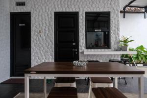 a dining room with a table and two black doors at RedDoorz Syariah near Perempatan Kartasuro in Solo