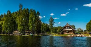 a log cabin on the shore of a lake at Chill Up in Vecpiebalga