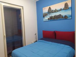 1 dormitorio con 1 cama con pared azul en Acitrezza Vacanze Mare, en Aci Castello