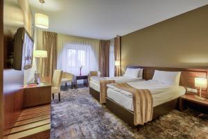 una camera d'albergo con due letti e una televisione di Golden Time Hotel a Braşov