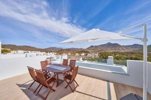 einen Tisch und Stühle auf einem Balkon mit Sonnenschirm in der Unterkunft Namasté in San José