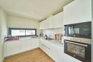 a kitchen with white cabinets and a stove top oven at Namasté in San José