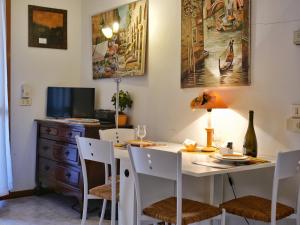 una sala da pranzo con tavolo e sedie bianchi di Cardellino, piccolo e accogliente dietro la spiaggia a Grado