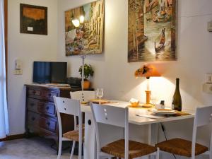 comedor con mesa blanca y sillas en Cardellino, piccolo e accogliente dietro la spiaggia, en Grado