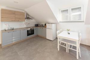 a kitchen with white appliances and a table and chairs at Apartments Linda in Brezje +22 photos