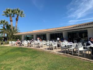 um grupo de pessoas sentadas em mesas e cadeiras em Piece of Paradise @ Balaia Golf Village, Albufeira, PORTUGAL - 4 STAR em Albufeira