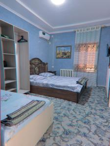 una camera con due letti e pareti blu di LION Guest House a Bukhara